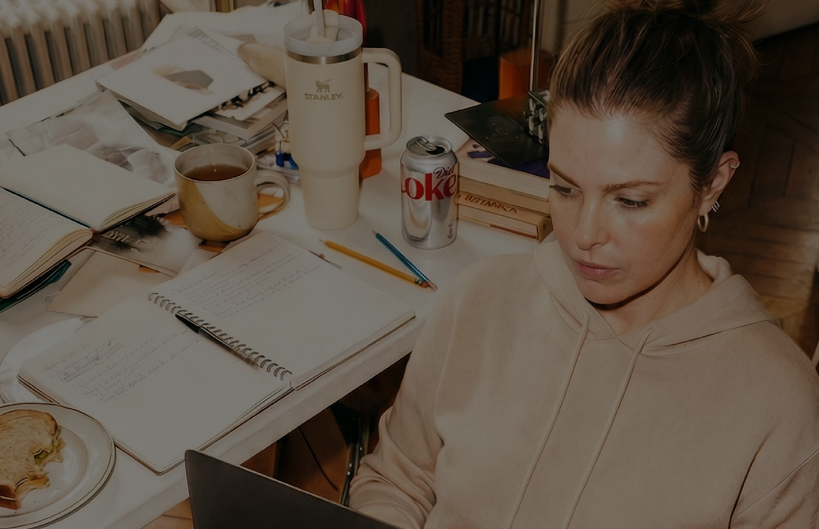 Woman with ADHD and a messy desk working at a laptop